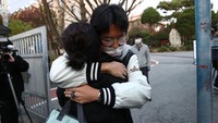 Seorang ibu memeluk putranya yang mengikuti College Scholastic Ability Test (CSAT) atau Suneung pada 17 November 2022 di Seoul, Korsel. Suneung adalah acara akademik tahunan paling penting di Korsel. Tes ini bisa membuat kegiatan di seluruh negeri terhenti. Tak hanya pelajar, orang tua pun ikut gugup menghadapi Suneung. Foto: Getty Images/Chung Sung-Jun