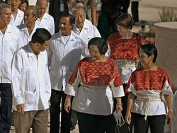 Di APEC 2002 yang berlangsung di Meksiko, para pria memakai guayabera berwarna putih. Seperti kemeja biasa, hanya saja baju ini memiliki kantong yang lebih banyak dan dihiasi detail bordiran. Adapun para wanita, seperti Presiden Megawati Soekarnoputri memakai tunik bermotif etnik yang dipermanis dengans sabuk tali. (Foto: AFP via Getty Images/ROBERTO SCHMIDT)