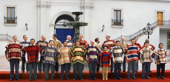 Giliran Chile menjadi tuan rumah APEC pada 2004. Seluruh kepala negara dan pemerintahan anggota APEC berfoto dalam balutan baju tradisional bernama chamanto, semaca luaran yang potongannya mirip poncho. Presiden Susilo Bambang Yudhoyono mendapat chamanto bernuansa merah. (Foto: AFP via Getty Images/OMAR TORRES)
