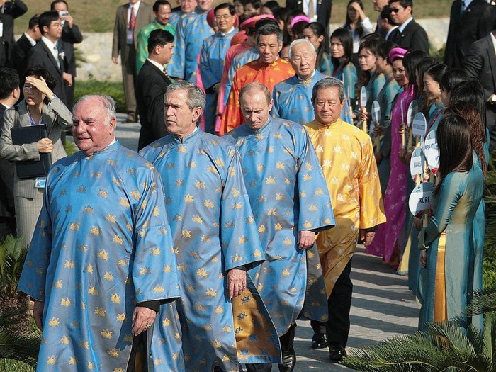 Hanoi, VIET NAM:  US President George W. Bush (2nd L), Russian President Vladimir Putin (C) and other leaders, all wearing a Vietnamese 'ao dai' silk tunics, walk out to take part in the official photograph for the Asian Pacific Economic Cooperation (APEC) summit in Hanoi, Vietnam 19 November 2006.         AFP PHOTO/Jim WATSON  (Photo credit should read JIM WATSON/AFP via Getty Images)