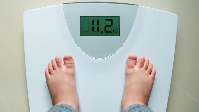 Healthy Weight Gain for Baby or Children Concept, A 2 Years Old Kid Standing on Weight Scales, Top View