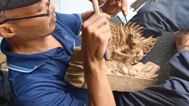 Perajin ukir di Desa Kedisan, Gianyar saat mengerjakan pesanan papan nama. Foto: IST