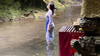 Raline Shah melakukan prosesi melukat di air terjun suci di tempat yang terpencil. Ia trekking dan sampai melepas alas kakinya untuk menuju air terjun tersebut. (Foto: Instagram @ralineshah)