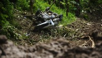 Sebuah mobil rusak parah setelah terseret tanah longsor.