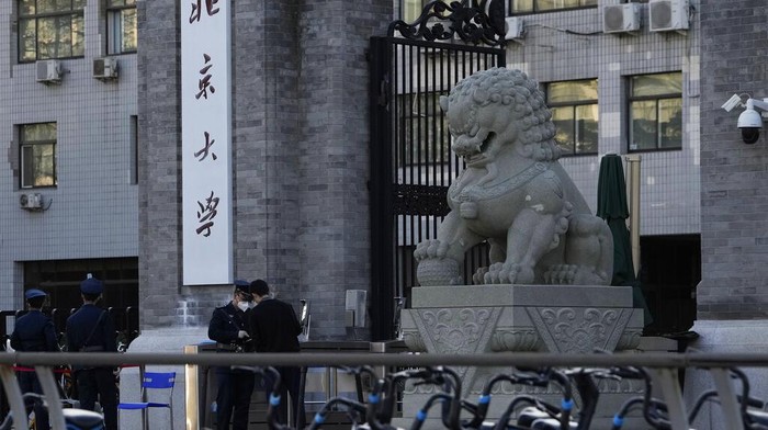 Universitas di Beijing Lockdown Usai Temuan Satu Kasus COVID-19 A security guard chats with another at an entrance to Peking University in Beijing, Wednesday, Nov. 16, 2022. Chinese authorities locked down the major university in Beijing on Wednesday after finding one COVID-19 case as they stick to a