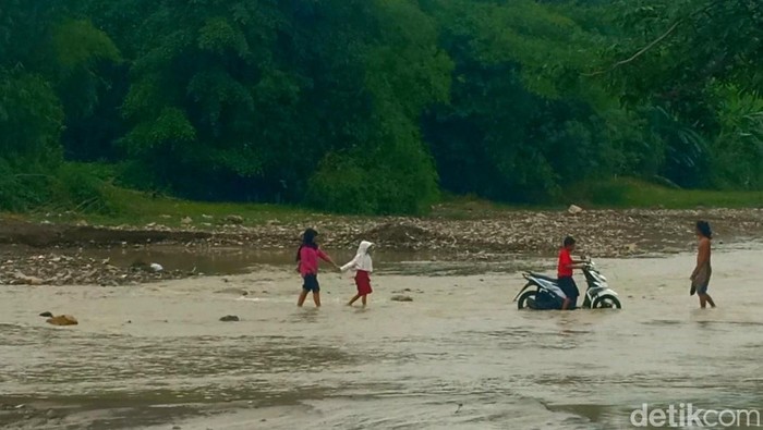 Warga Kamal Brebes seberangi sungai gegara akses utama mereka putus, Kamis (17/11/2022).