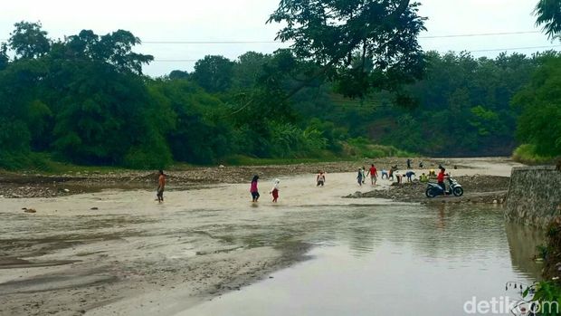 Warga Kamal Brebes seberangi sungai gegara akses utama mereka putus, Kamis (17/11/2022).