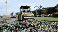 Ribuan botol minuman keras itu dimusnahkan dengan cara digilas alat berat.