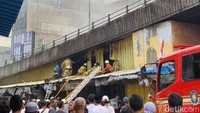 Petugas Damkar membongkar dinding seng untuk memadamkan kebakaran kios di Pasar Pagi Asemka di Jakbar. (Indah Mutiara Kami/detikcom)