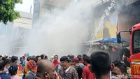 Di sekitar lokasi, tampak warga berkumpul menyaksikan proses pemadaman. Ada juga pedagang yang menyelamatkan barang dagangannya. (Indah Mutiara Kami/detikcom)