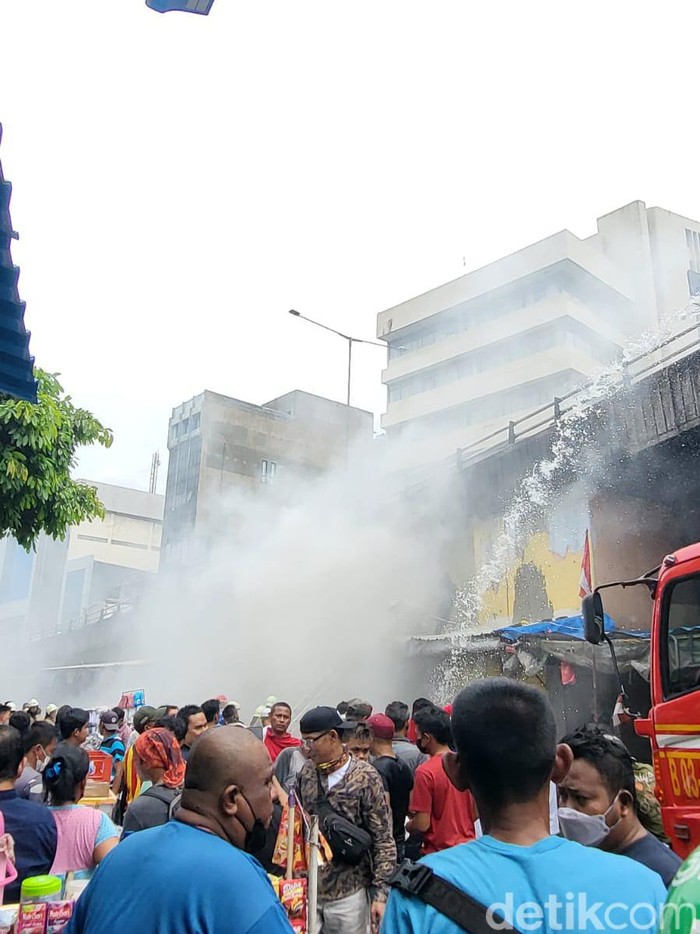 Damkar berupaya memadamkan kebakaran di Pasar Pagi Asemka di Jakbar. Asap putih membubung saat proses pemadaman api berjalan. (Indah Mutiara Kami/detikcom)