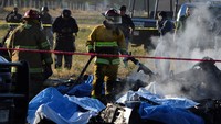 Petugas pemadam kebakaran berusaha memadamkan api yang membakar helikopter usai kecelakaan.