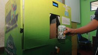 Siswa memasukkan sampah kaleng minuman ke dalam ATM Pemilah Sampah. Mesin tersebut memiliki sensor sampah logam, organik, dan anorganik.