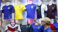 Pedagang menunjukkan jersey-jersey negera peserta Piala Dunia seperti Brasil, Portugal hingga Jerman.