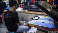 Pedagang sedang membungkus jersey Argentina. Jelang Piala Dunia, jersey tersebut paling banyak diminati oleh pembeli.