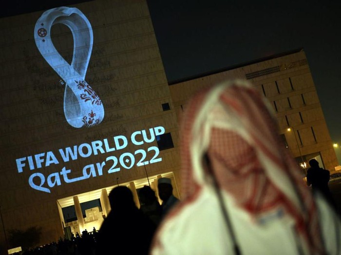 People gather at the capital Dohas traditional Souq Waqif market while the official logo of the FIFA World Cup Qatar 2022 is projected on the front of a building on September 3, 2019. (Photo by - / AFP)        (Photo credit should read -/AFP via Getty Images)