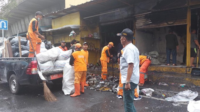 Pasukan oranye dan warga bersihkan puing sisa kebakaran Pasar Pagi Asemka. (Rumondang/detikcom)
