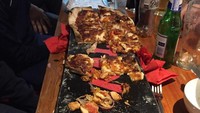 Tak seperti restoran pizza pada umumnya, ada penyajian unik dan ekstrem yang diberikan oleh pelanggannya. Tanpa piring maupun baki, potongan pizza akan disajikan di atas papan untuk berseluncur di atas salju. Foto: Bored Panda