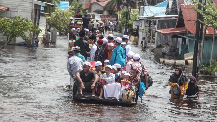 Sejumlah warga menerobos banjir yang merendam di kawasan Jalan Anoi, Palangka Raya, Kalimantan Tengah, Kamis (17/11/2022). Berdasarkan data Badan Penanggulangan Bencana Daerah (BPBD) setempat, banjir luapan Sungai Kahayan yang dipicu oleh faktor cuaca tersebut merendam 1.733 unit rumah dan mengakibatkan 2.388 kepala keluarga (KK) serta 8.544 jiwa di kota itu terdampak banjir. ANTARA FOTO/Makna Zaezar/foc.