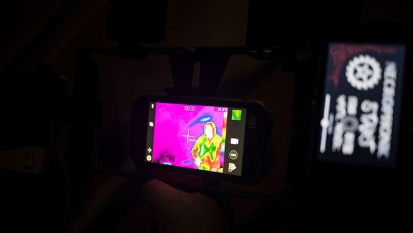 Seorang anggota kelompok pemburu hantu, The Upsidedown, menunjukkan pembacaan termal saat menyelidiki aktivitas paranormal.  