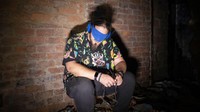 Nigel Mullinder (29) anggota kelompok pemburu hantu The Upsidedown, mendengarkan meteran frekuensi radio dengan mata tertutup di dalam gedung terbengkalai di salah satu kampus top Afrika Selatan sambil mencari tanda-tanda aktivitas paranormal.