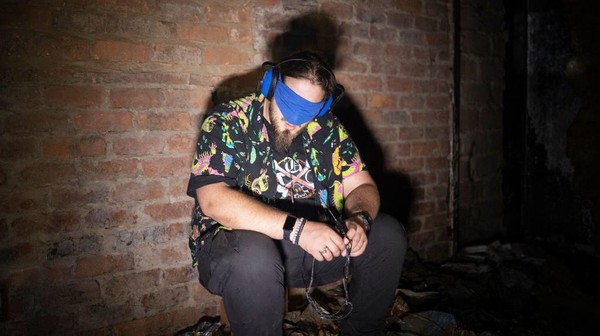 Nigel Mullinder (29) anggota kelompok pemburu hantu The Upsidedown, mendengarkan meteran frekuensi radio dengan mata tertutup di dalam gedung terbengkalai di salah satu kampus top Afrika Selatan sambil mencari tanda-tanda aktivitas paranormal.