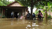 Warga memilih untuk bertahan meski banjir menggenangi rumahnya.