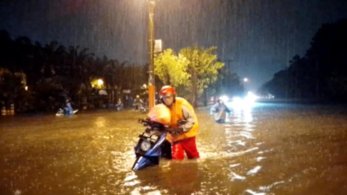 banjir medan Ditengah banjir dan guyuran hujan di Medan, pengendara berusaha mendorong sepeda motor keluar dari genangan air. Farid Achyadi Siregar/detikSumut