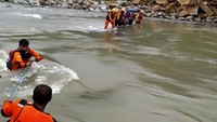 Tim SAR gabungan menyeberangi sungai untuk mencari korban tanah longsor di Desa Lonjoboko, Kabupaten Gowa, Sulawesi Selatan.