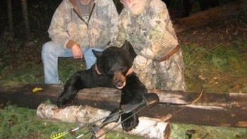 Saat para pemburu ini mengambil beruang hitam sebagai piala; mereka gagal memperhatikan anggota keluarga si beruang di belakang mereka. Foto: Postoast
