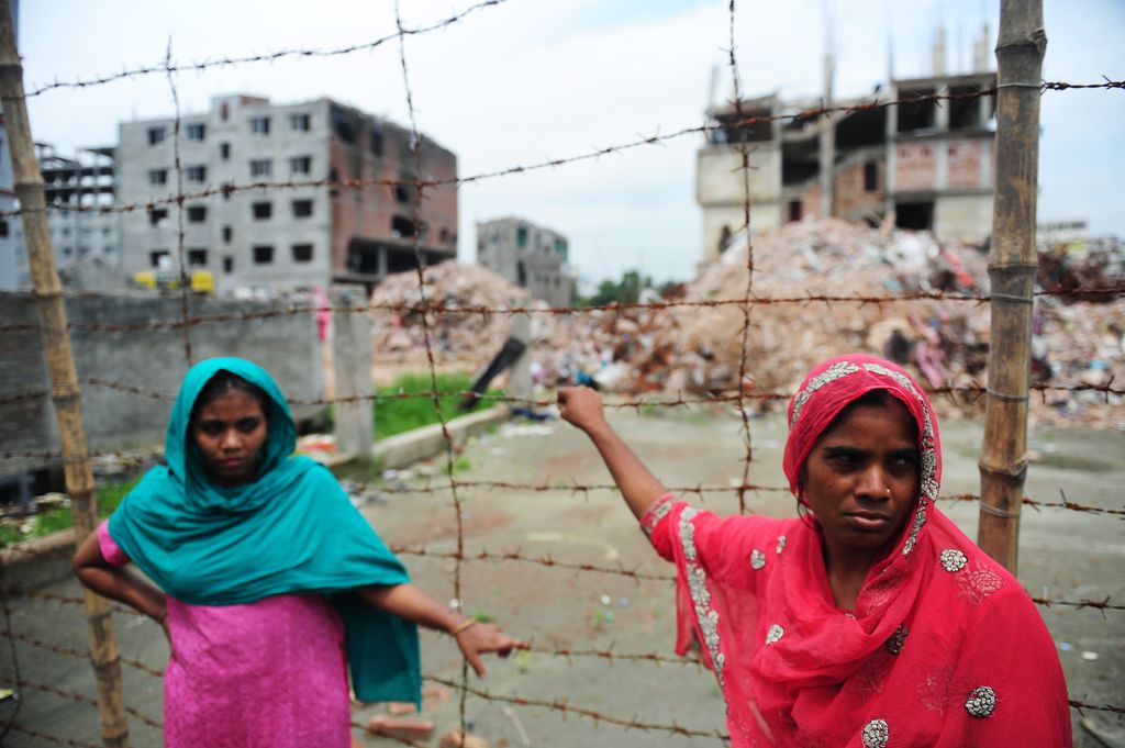 Nasima Akter (L) and another Bangladeshi labourer, that worked inside the collapsed building and was rescued, looks on two months after  a nine-storey building collapse in Savar, on the outskirts of Dhaka on June 24, 2013.  Hundreds of garment workers staged demonstrations at the site of Bangladesh's worst industrial disaster, demanding compensation for the survivors and a full account of the missing labourers. AFP PHOTO/ Munir uz ZAMAN        (Photo credit should read MUNIR UZ ZAMAN/AFP via Getty Images)