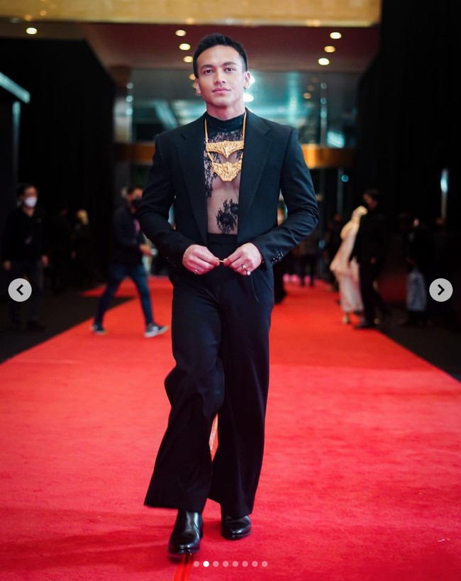 Jefri Nichol mulai mendapat julukan ‘Harry Styles Indonesia’ karena kerap bergaya mendobrak batas gender seperti mantan personel One Direction. Saat menghadiri Festival Film Indonesia 2021, dia membuat penggemar pangling dengan penampilannya memakai atasan transparan berbahan lace dan blazer hitam, lengkap dengan kalung emas bernuansa tradisional. Foto: Instagram