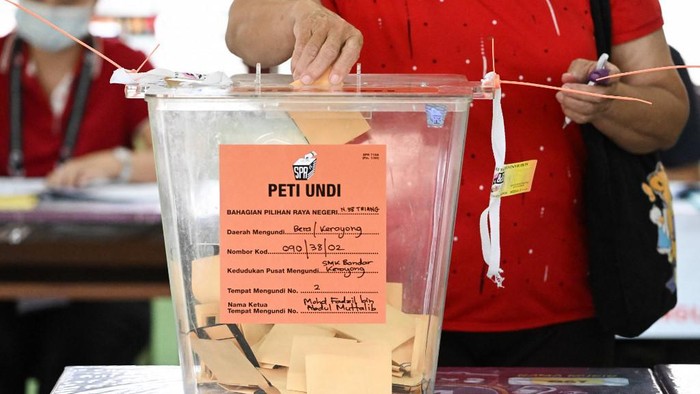 A woman casts her vote at a polling station in Bera, during the 15th general election in Bera, Malaysias Pahang state on November 19, 2022. (Photo by Mohd RASFAN / AFP)