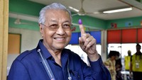 Mahathir Mohamad menunjukkan jari yang sudah dicelupkan ke tinta. Jari yang sudah tercelup tinta itu sebagai tanda sudah memberikan hak suara dalam Pemilu Malaysia. AP Photo/JohnShen Lee.