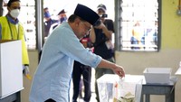 Anwar Ibrahim memasukkan surat suara ke kotak suara dalam Pemilu Malaysia. AP Photo/Vincent Thian.