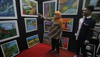 Gubernur Jawa Timur Khofifah Indar Parawansa melihat lukisan karya pelukis penyandang disabilitas Rizky Gusti Preyambodo di salah satu stan. Sekitar 3.000 karya lukisan yang ada di pameran ini juga dimanfaatkan sebagai ajang pertemuan para pelukis, kolektor, dan masyarakat pecinta seni lukis.