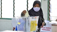 Warga memasukkan surat suara ke kotak suara usai memberikan hak suaranya. AP Photo/JohnShen Lee.