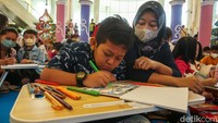 Anak-anak itu mengikuti lomba mewarnai dengan didampingi orangtuanya. 