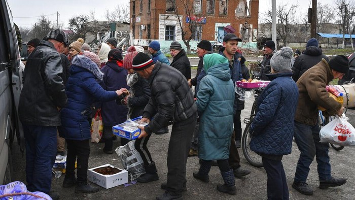 Saat Warga Ukraina Antre Pasokan Makanan dan Pakaian Bekas Warga Ukraina menerima pasokan makanan di titik bantuan kemanusiaan di desa Drobysheve, wilayah Donetsk, Ukraina. (AP Photo/Andriy Andriyenko)