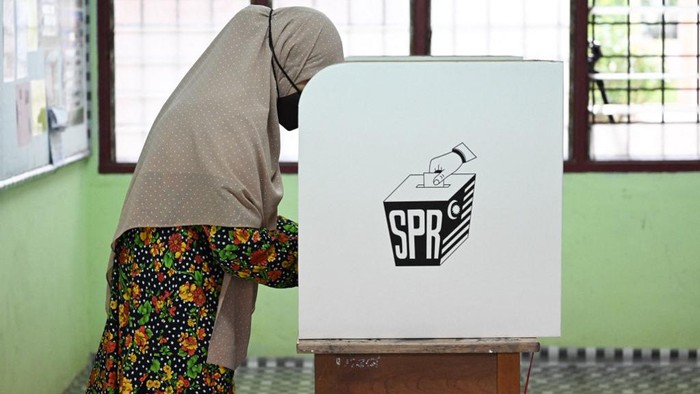 A woman casts her vote at a polling station during the 15th general election in Bera, Malaysias Pahang state on November 19, 2022. (Photo by Mohd RASFAN / AFP)