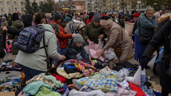 Sejumlah warga antre di titik distribusi bantuan di pusat kota Kherson, Ukraina selatan, Jumat (18/11/2022). (AP Photo/Bernat Armangue)
