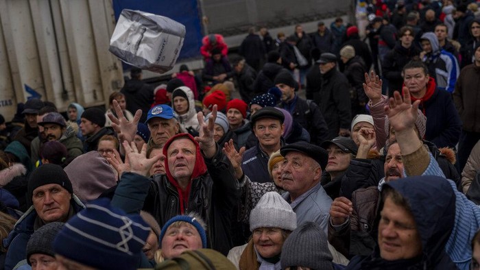 Warga Ukraina Antre Pasokan Makanan dan Pakaian Bekas Sejumlah warga antre di titik distribusi bantuan di pusat kota Kherson, Ukraina selatan, Jumat (18/11/2022). (AP Photo/Bernat Armangue)