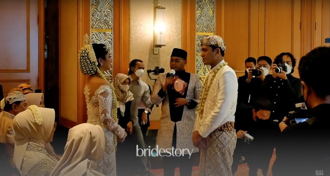 Glenca dan Rendi tampil kompak mengenakan busana pengantin Jawa berwarna putih. Glenca cantik mempesona dengan kebaya putih yang dipenuhi payet lengkap dengan paes dan konde di kepalanya. Foto: YouTube/Glenca Chysara