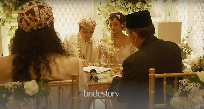 Glenca dan Rendi kemudian menyelesaikan penandatanganan berkas-berkas pernikahan mereka dengan disaksikan oleh orangtua, penghulu, para saksi serta tamu undangan yang hadir. Foto: YouTube/Glenca Chysara