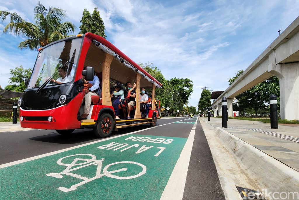 Pesepeda dan pejalan kaki menikmati jalur pedestrian di kawasan Taman Mini Indonesia Indah (TMII), Jakarta Timur, Minggu (20/11/2022).