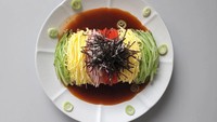 Bibimyeon merupakan hidangan mie berbumbu asam, pedas, dan manis. Penyajian bibimyeon ini tampak menggiurkan karena topping-nya dibuat sejajar dan warnanya cantik. Ada telur, mentimun, tomat, lobak, hingga rumput laut kering. Foto: Instagram @sibatable