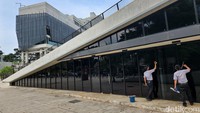 Pekerja mengelap kaca di bagian depan kawasan TIM. Penggunaan kaca yang besar dan maksimal membutuhkan perawatan rutin. Pun demikian, kaca mempunyai kelebihan menyaring cahaya alami dan mengurangi biaya cahaya buatan.  