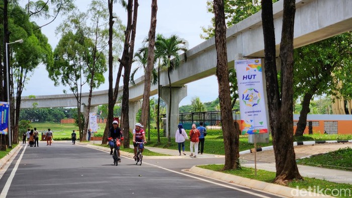 Pengunjung menikmati suasana taman  dan angin sepoi sepoi yang sejuk di kawasan TMII, Jakarta, Minggu (20/11/2022).