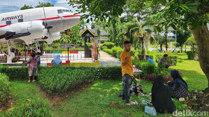 Pengunjung menikmati suasana taman dan angin sepoi sepoi yang sejuk di kawasan TMII, Jakarta, Minggu (20/11/2022).