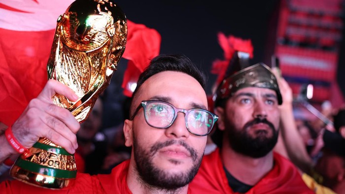 DOHA, QATAR - NOVEMBER 19: A fan of Tunisia holds a replica of the World Cup Trophy during the Fan Festival Official Opening ahead of the FIFA World Cup 2022 Qatar Fan Festival at Al Bidda Park on November 19, 2022 in Doha, Qatar. (Photo by Gonzalo Arroyo - FIFA/FIFA via Getty Images)